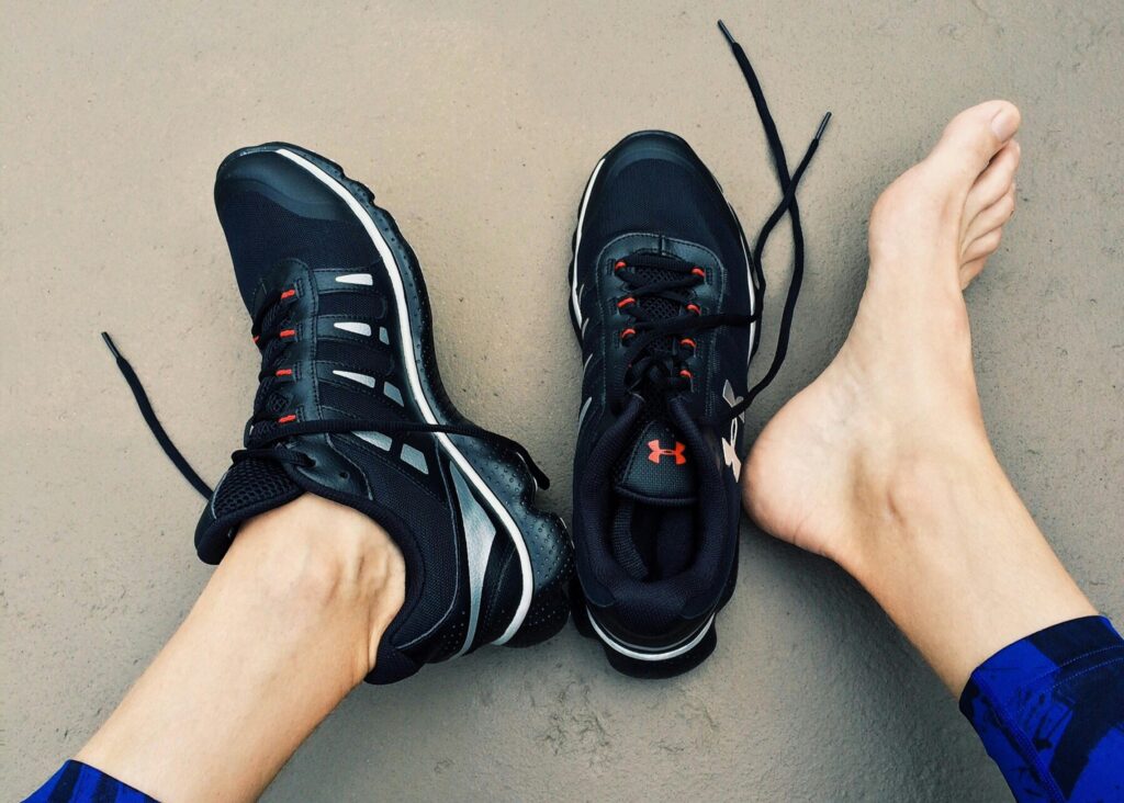 A person putting on black running shoes, preparing for a run.