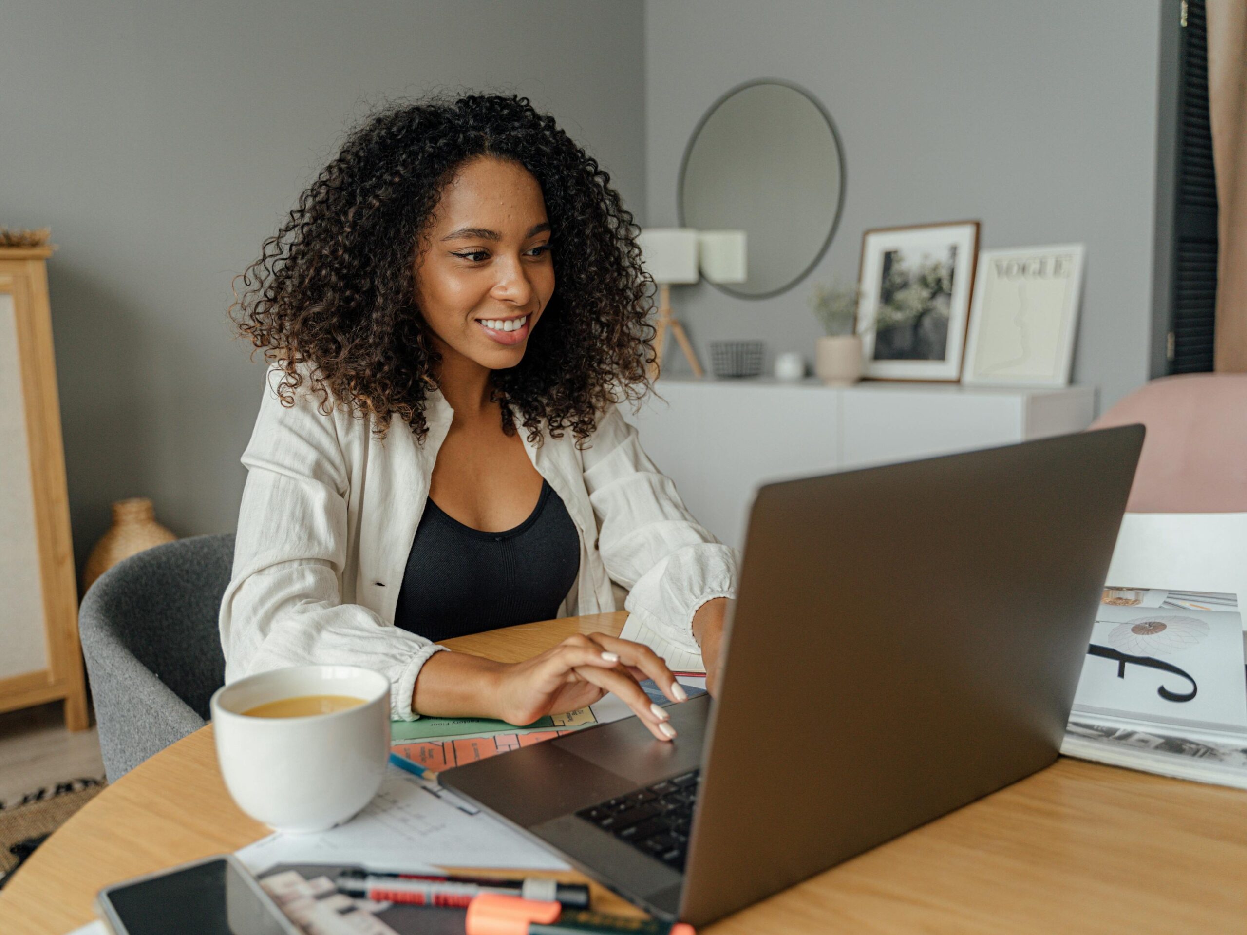 Woman smiling during a virtual meeting on her computer, sitting at her desk in her home office.